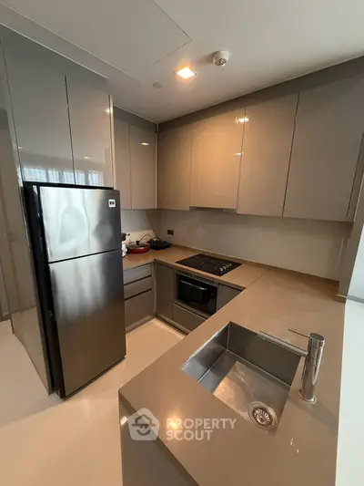 Modern kitchen with sleek cabinetry and stainless steel appliances in a contemporary apartment.