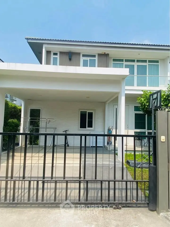 Modern two-story house with gated driveway and sleek design