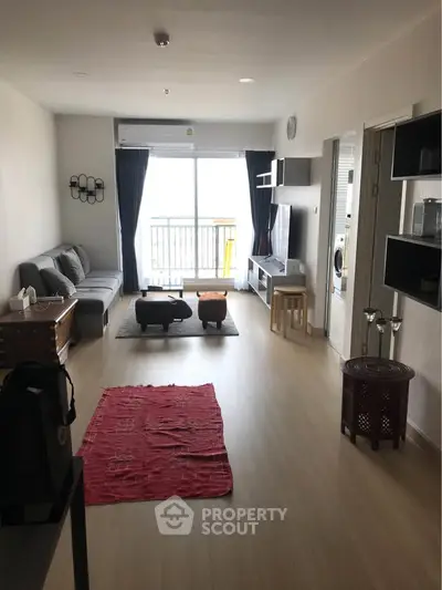 Spacious living room with modern decor and balcony access in a stylish apartment.
