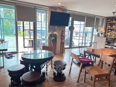 Spacious living room with large windows and stylish furniture, perfect for relaxation and entertaining.
