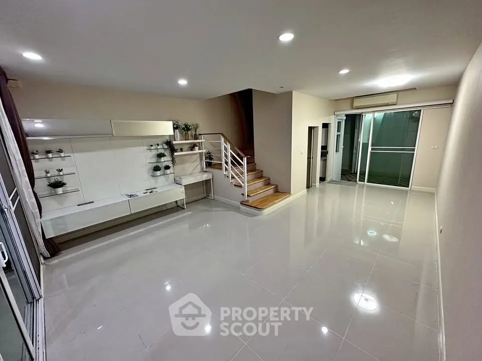 Spacious modern living room with sleek staircase and large windows