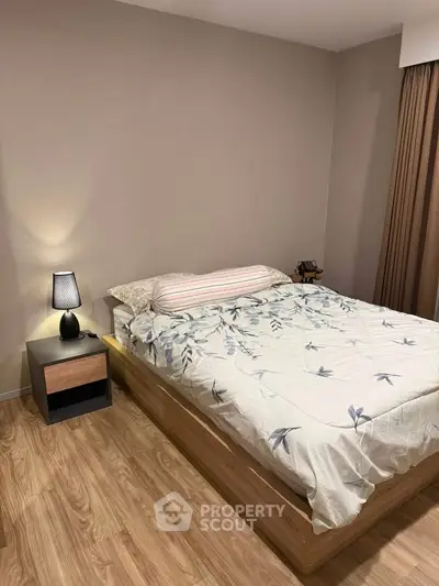 Cozy bedroom with modern wooden flooring and stylish bedside lamp