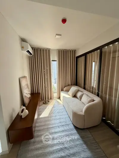 Stylish living room with modern sofa, elegant curtains, and natural light creating a cozy ambiance.