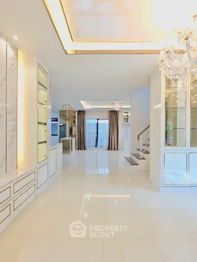 Luxurious open-plan living area with elegant chandelier and marble accents