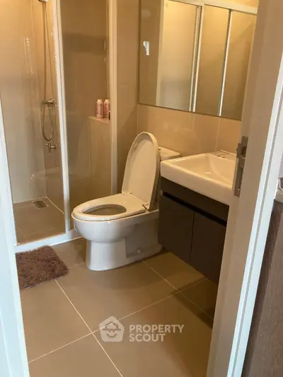 Modern bathroom with glass shower and sleek fixtures in contemporary apartment.