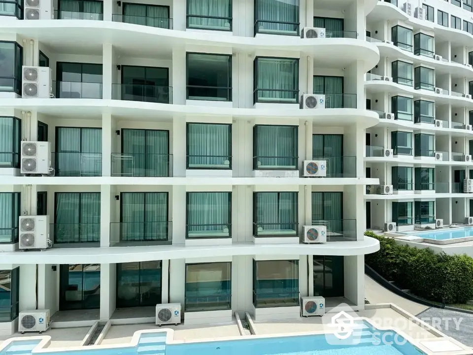 Modern apartment building with balconies and pool view