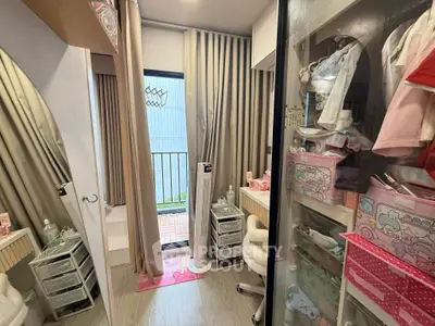 Charming small bedroom with balcony access, featuring organized storage and cozy decor.