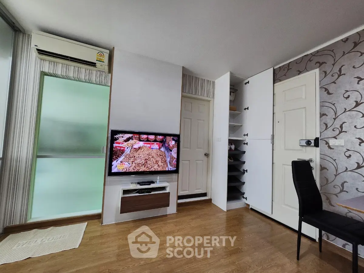 Modern living room with stylish decor and wall-mounted TV in a cozy apartment.