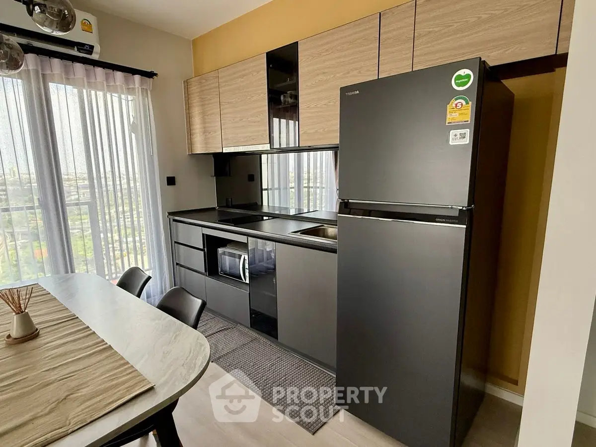 Modern kitchen with sleek black appliances and stylish dining area