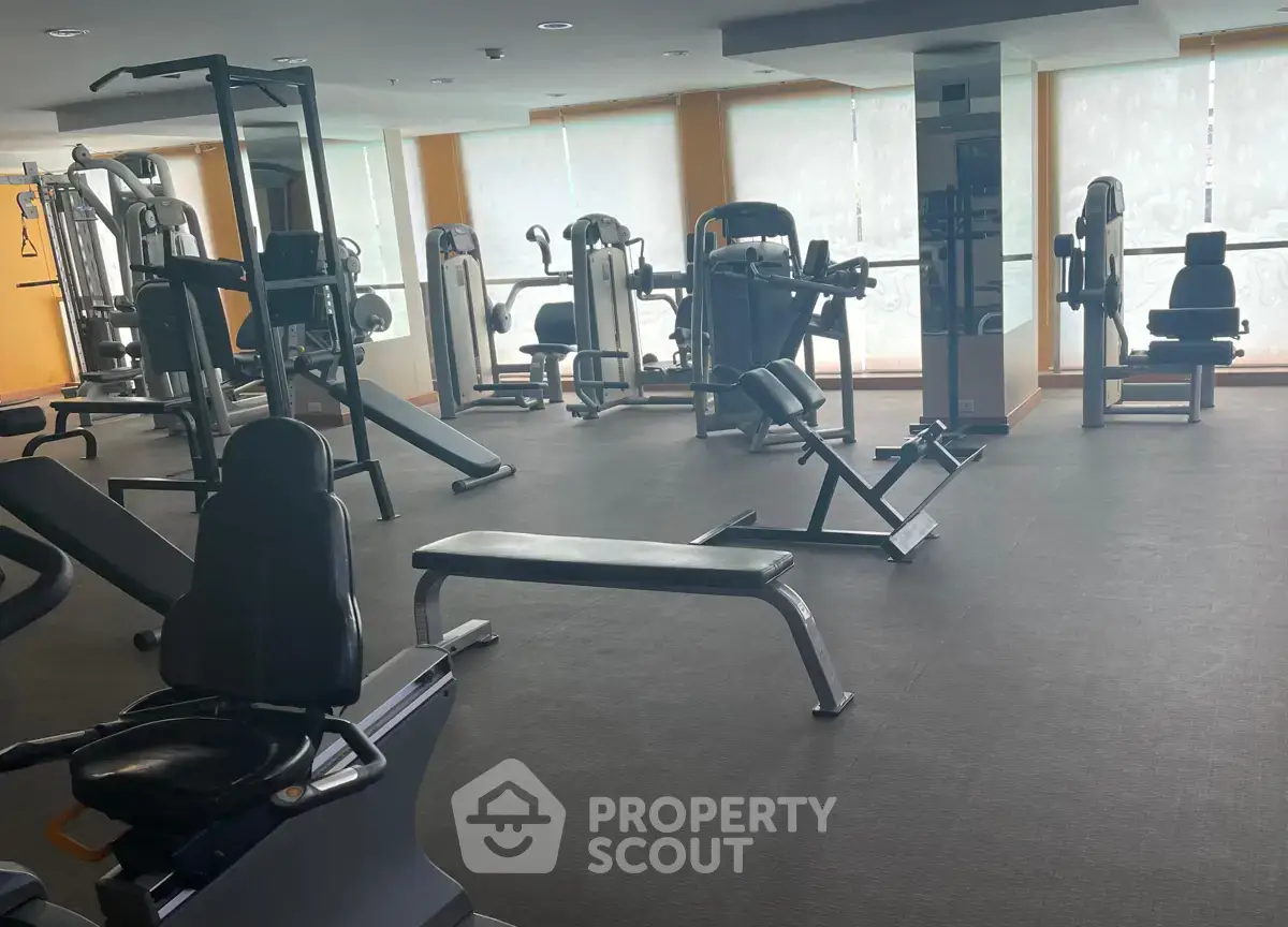 Spacious gym with modern fitness equipment in a well-lit room, ideal for active lifestyle enthusiasts.