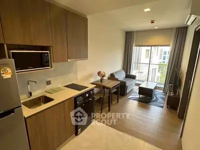 Modern open-layout kitchen and living room with stylish furnishings and natural light.