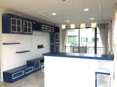 Modern kitchen with blue cabinetry and stylish lighting in open layout apartment