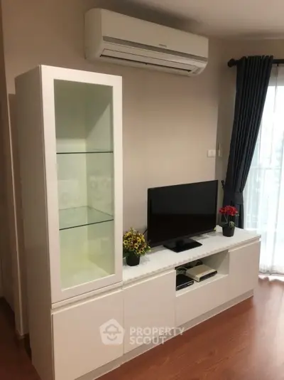 Modern living room with sleek white furniture and air conditioning unit