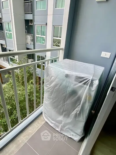 Modern apartment balcony with covered appliance and city view