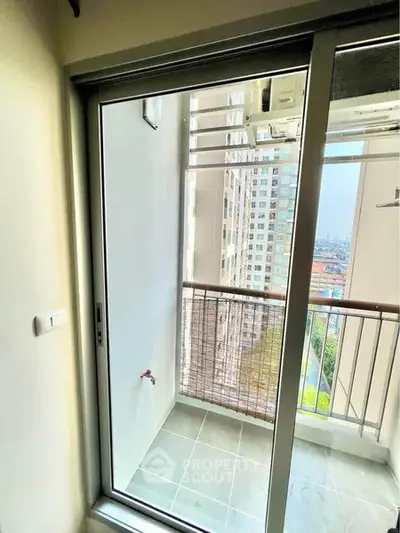 Modern apartment balcony with sliding glass door and city view