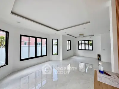 Spacious modern living room with large windows and glossy tile flooring in a bright, open layout.