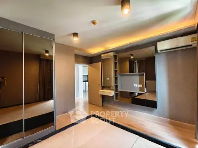 Spacious modern bedroom with mirrored wardrobe and ambient lighting
