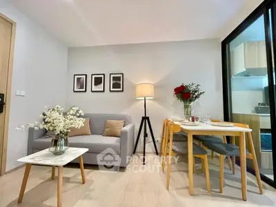 Modern living room with cozy sofa, stylish decor, and dining area in open layout apartment.
