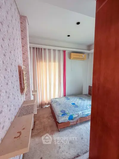Cozy bedroom with air conditioning and natural light through sheer curtains.