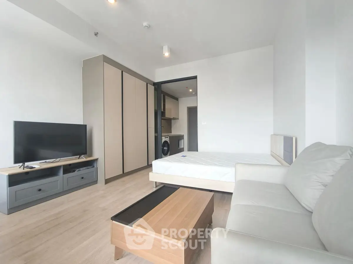 Modern studio apartment with cozy living area and sleek kitchen