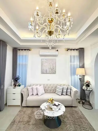 Elegant living room with chandelier, plush sofa, and stylish decor