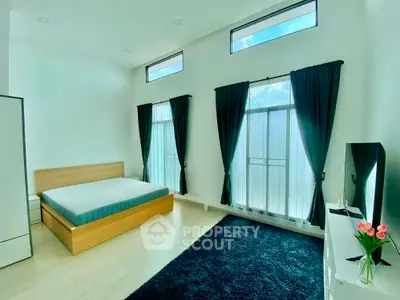 Spacious modern bedroom with large windows and elegant decor