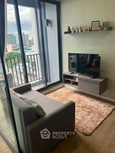 Modern living room with balcony view, stylish decor, and cozy seating in urban apartment.