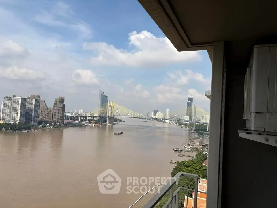 Stunning river view from high-rise balcony with cityscape and bridge in the background.