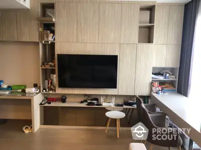 Modern living room with built-in wooden cabinets and large TV