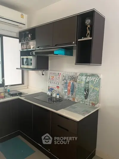 Modern kitchen with sleek cabinets and stylish decor, featuring a compact layout and contemporary appliances.