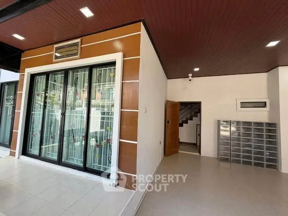 Modern entrance with stylish glass doors and sleek tile flooring in a contemporary home.