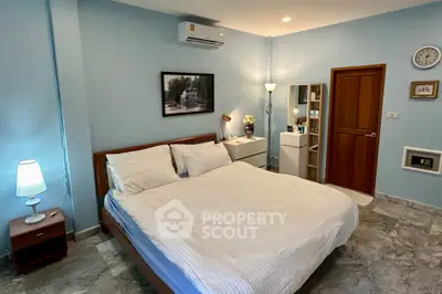 Cozy bedroom with modern decor and marble flooring, featuring a comfortable bed and stylish lighting.