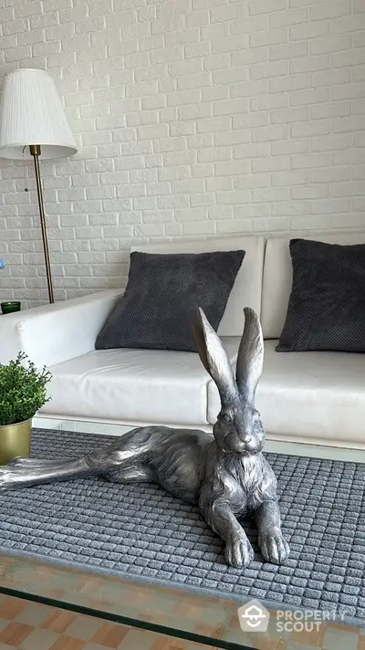 Stylish living room with modern decor and unique rabbit sculpture centerpiece.