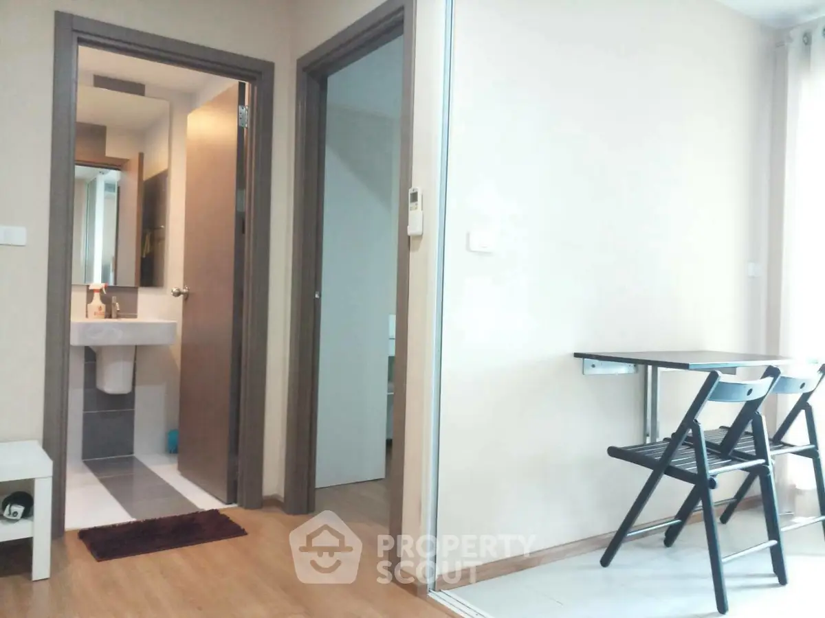 Modern apartment interior with compact dining area and bathroom view