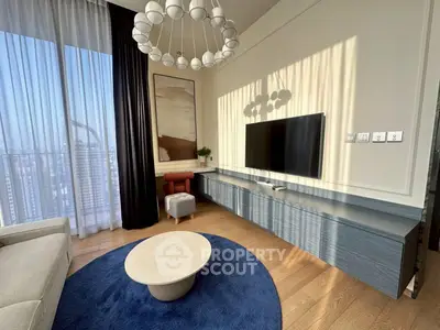 Modern living room with stylish decor, large windows, and city view, featuring a sleek TV setup and elegant lighting.