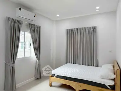 Modern minimalist bedroom with natural light and air conditioning