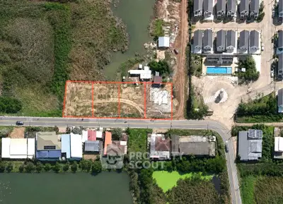 Aerial view of residential development site with adjacent houses and pool, showcasing potential for new construction.