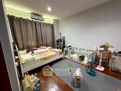 Cozy bedroom with wooden flooring, pet area, and modern decor