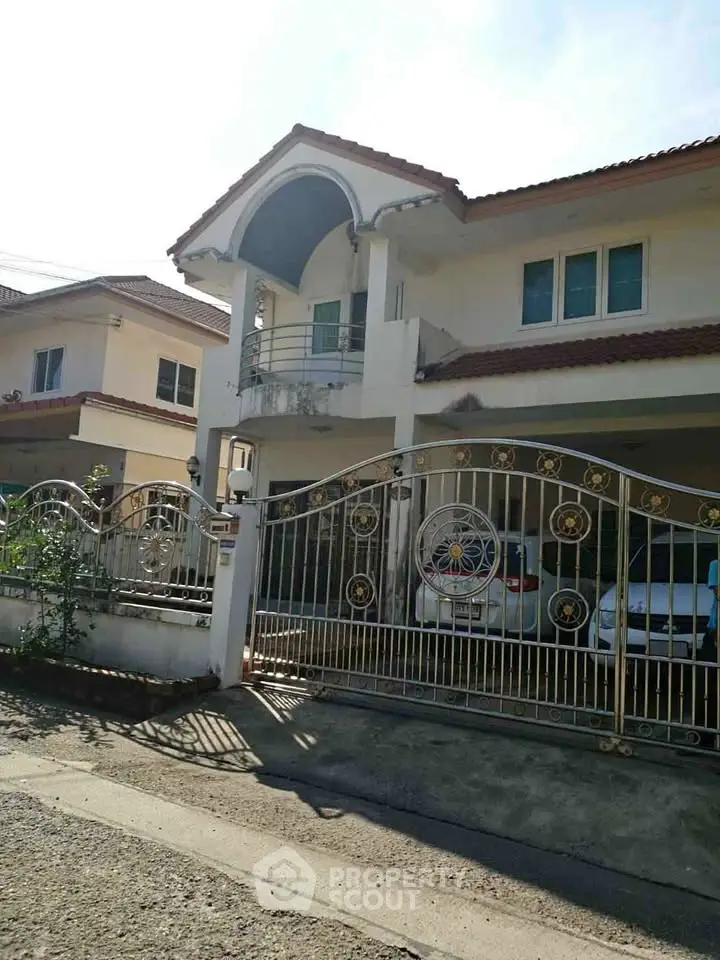 Elegant two-story house with gated entrance and spacious driveway in suburban neighborhood.