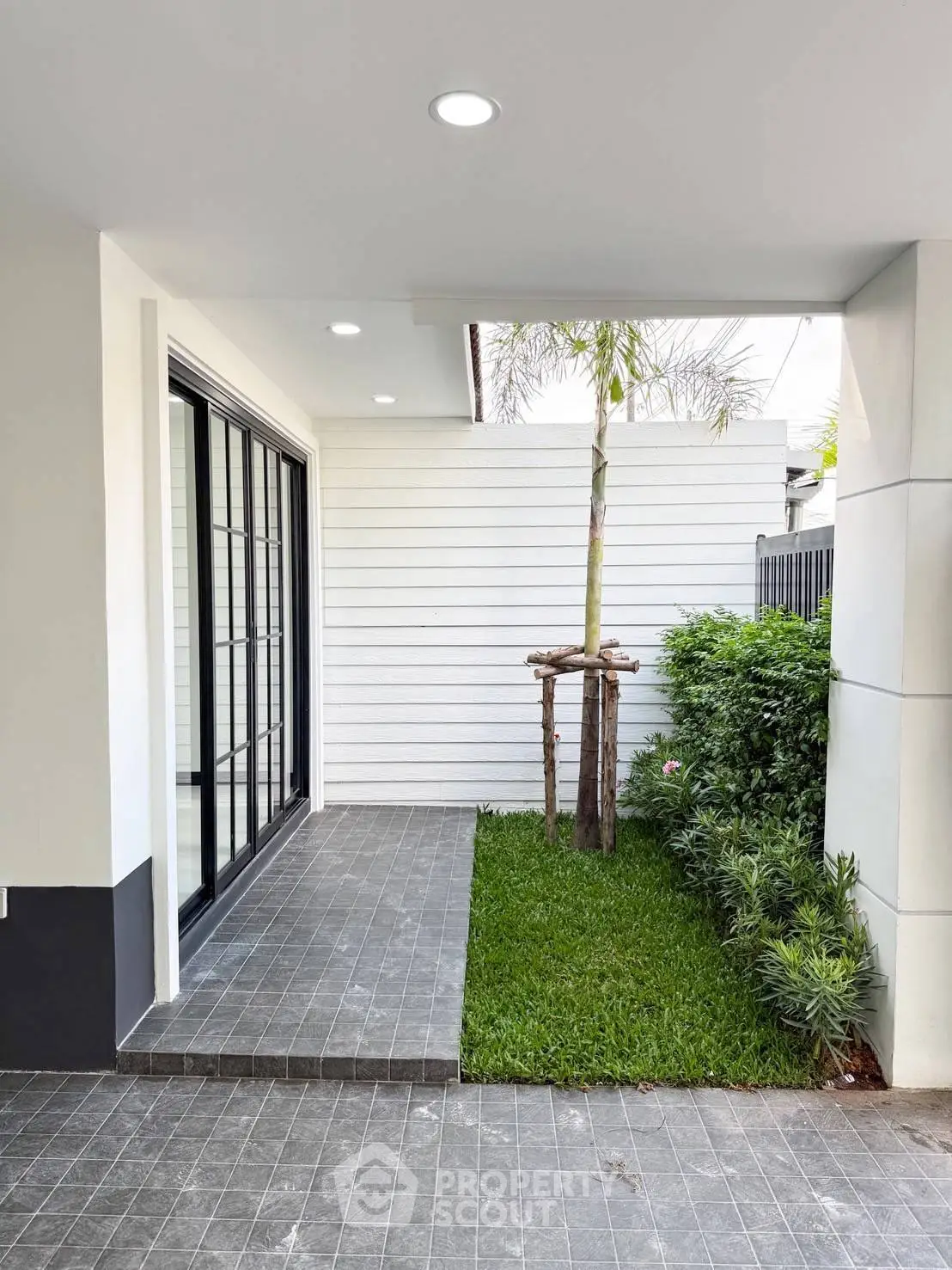Modern exterior with sleek patio and lush greenery
