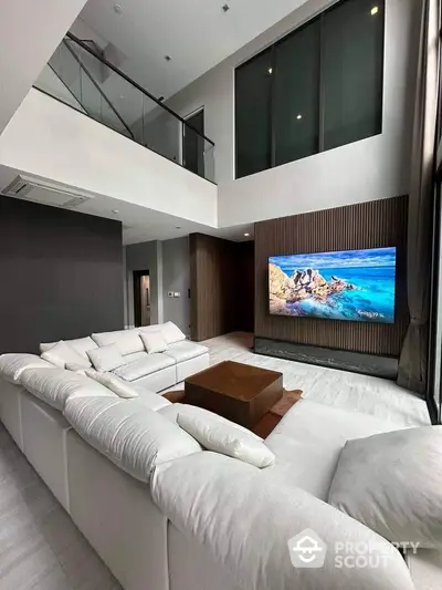 Luxurious modern living room with high ceilings and large TV