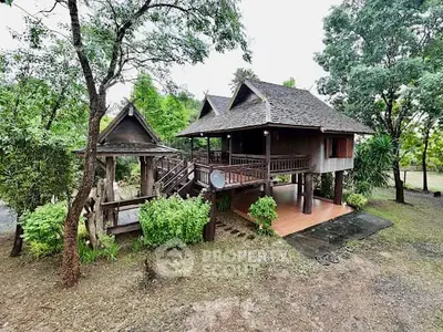 Charming elevated wooden house with lush greenery and traditional architecture.