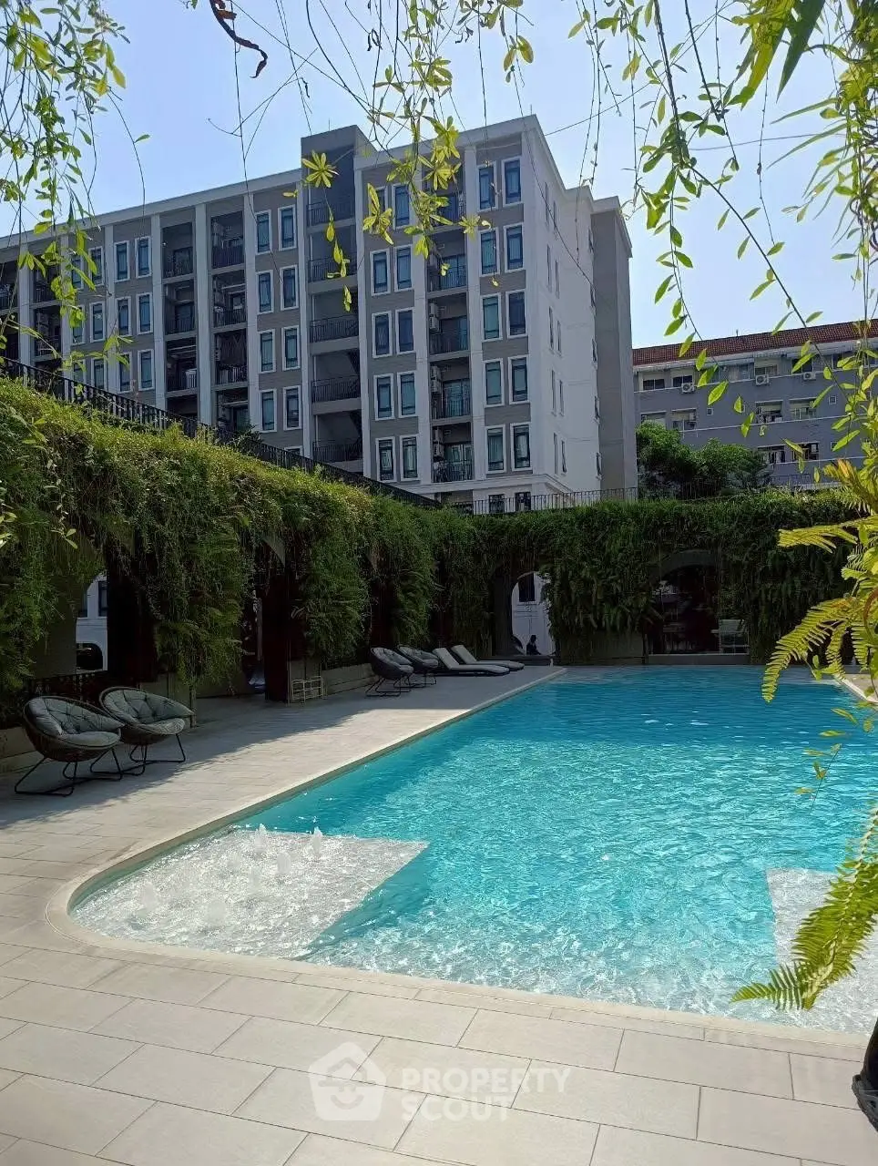 Luxurious apartment complex with stunning pool and lush greenery