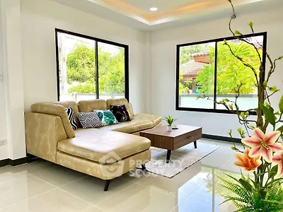Bright and airy living room with modern beige sofa and lush garden view.