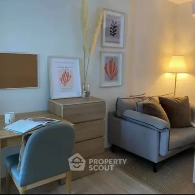 Cozy living room with stylish decor, featuring a comfortable sofa, desk, and elegant wall art.