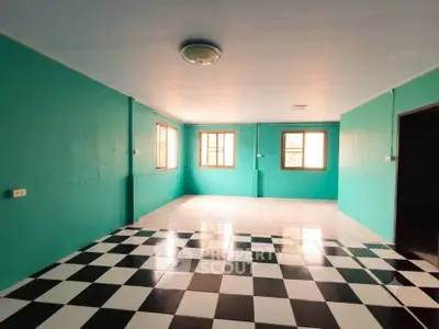 Spacious room with vibrant teal walls and checkered flooring, ideal for creative interior design.