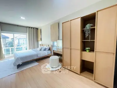 Spacious bedroom with modern decor and balcony access in a stylish home.