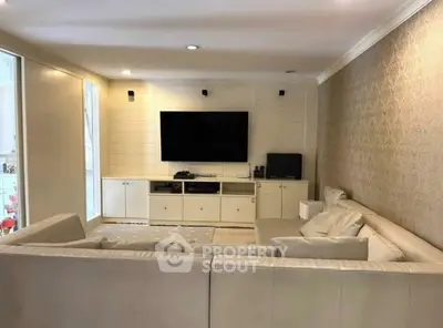 Spacious living room with modern decor and large TV, perfect for entertainment and relaxation.