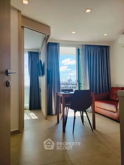 Modern apartment interior with natural light, featuring a cozy living area and city view.