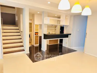 Modern interior with stylish lighting and open layout near staircase